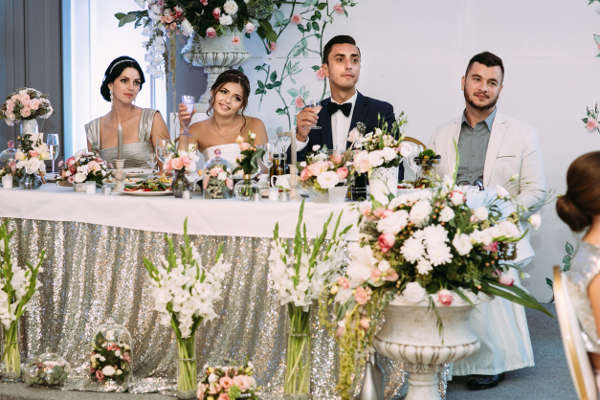 Bride and groom are holding a glasses of champagne
